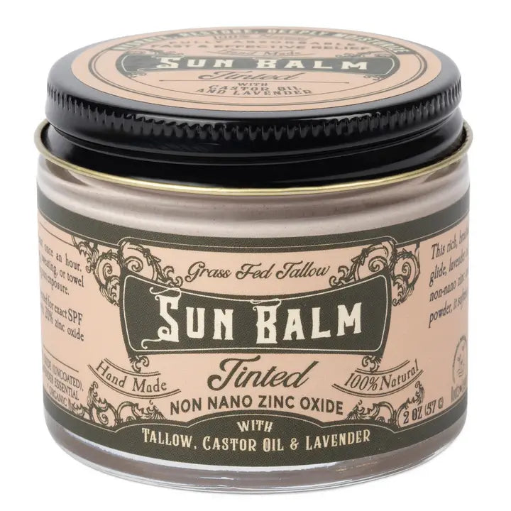A jar of Grass Fed Tallow Sun Balm in the Tinted scent, featuring a beige label with black text and a black lid, set against a plain white background.