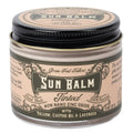 A jar of Grass Fed Tallow Sun Balm in the Tinted scent, featuring a beige label with black text and a black lid, set against a plain white background.